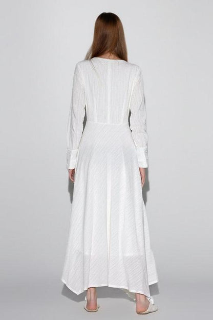 Woman wearing a white dress against a plain background