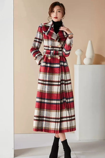 A woman wearing a long red plaid wool coat with a belt, button closure, and two side pockets.
