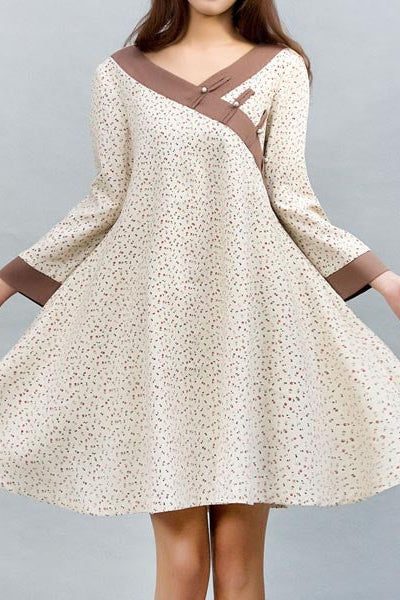 A woman modeling a cream linen shirt swing shirt dress with 3/4 sleeves and a round collar, featuring a loose style and chiffon lining.